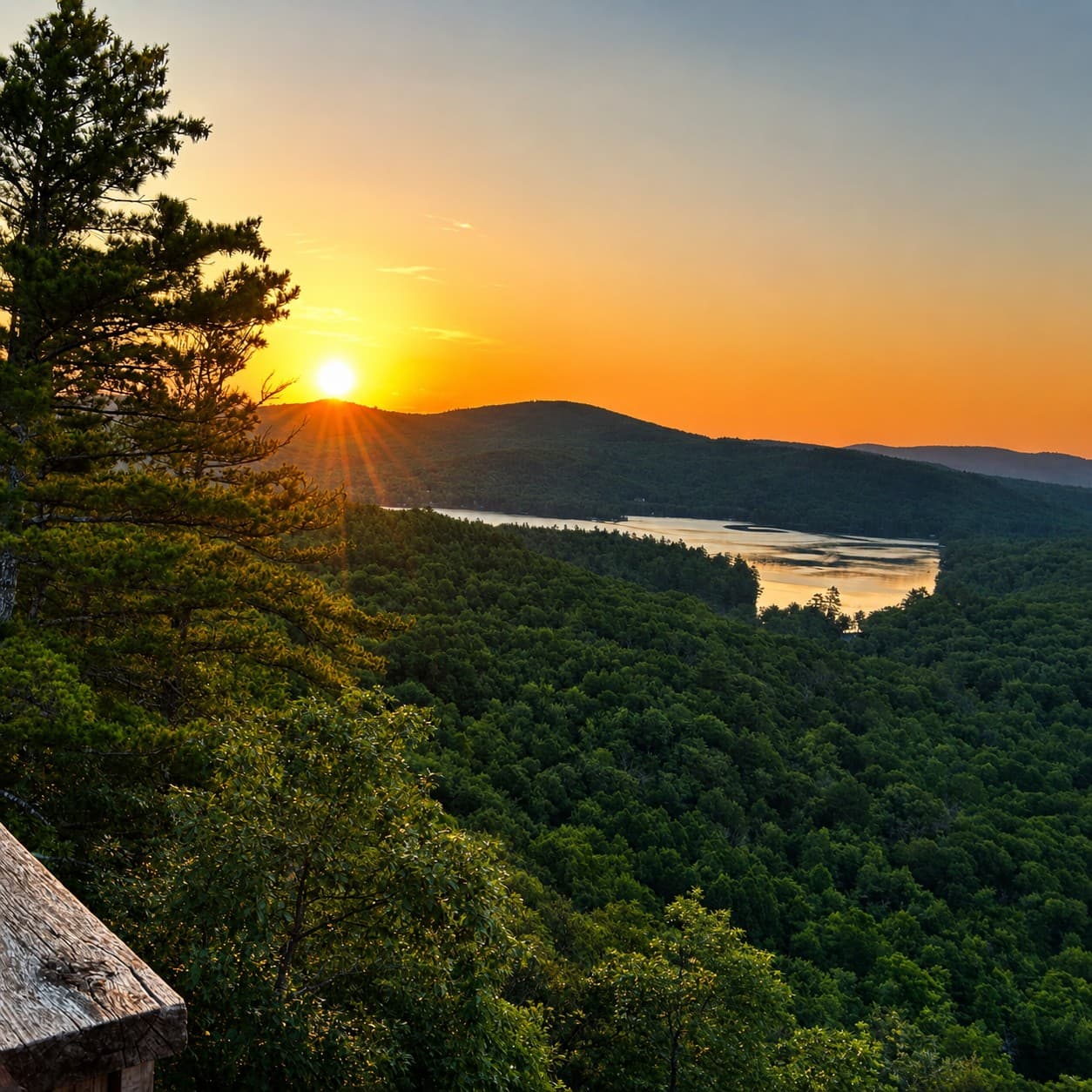 Sunrise over the lake and White Mountains from the summit tower at In The Trees, Maine